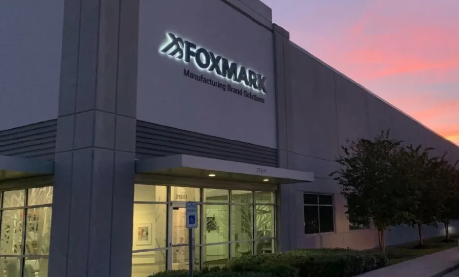 Foxmark wide-format printing facility featuring flatbed press, RollsRoller media handling system, and Foxmark logo wall graphic